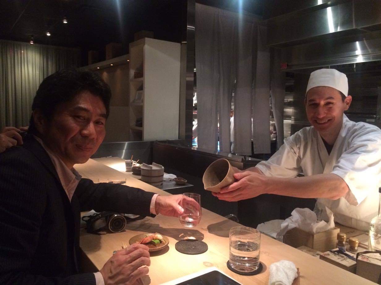 Kevin Cory serves Nichiei AD sake in Ohi pottery (pitcher made by Toshio Ohi, gifted by Nakamura Brewery president, Taro Nakamura) to Naogen soy sauce president, Junichiro Naoe.  Photo by Manami Naoe.